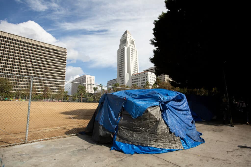 homeless encampment tent with government buildings in background